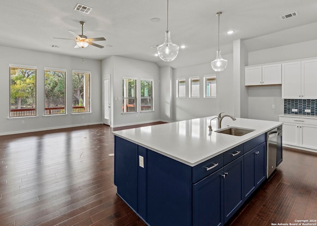 kitchen with dark hardwood / wood-style flooring, sink, an island with sink, blue cabinetry, and white cabinetry