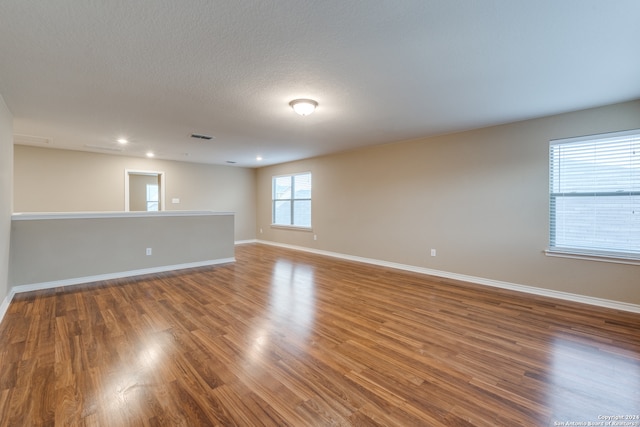 unfurnished room featuring a textured ceiling and hardwood / wood-style flooring