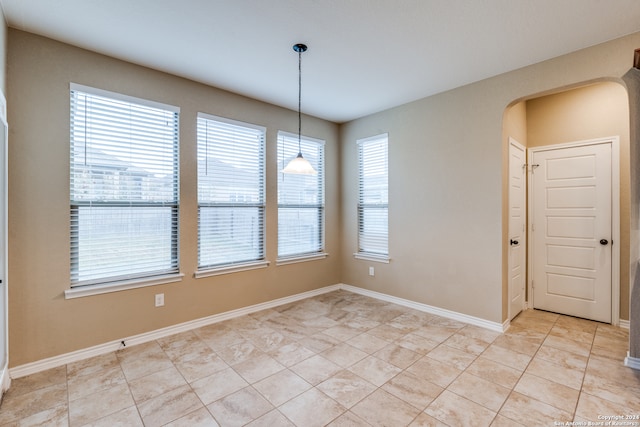 empty room featuring a wealth of natural light and light tile patterned floors