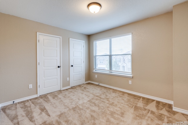 spare room featuring light colored carpet