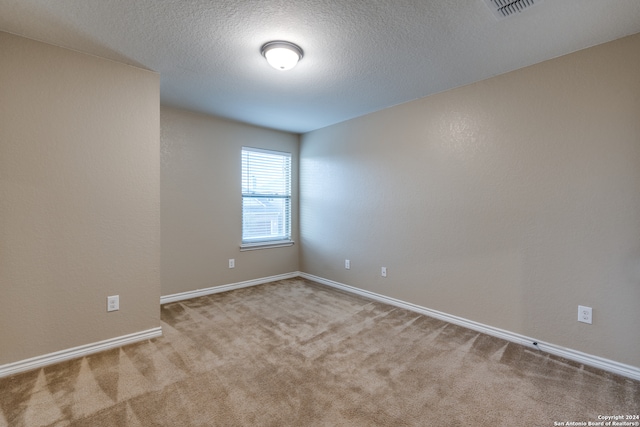 carpeted spare room with a textured ceiling