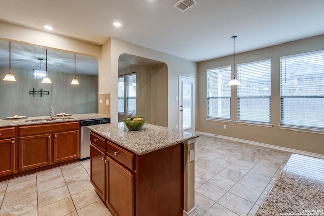 kitchen with hanging light fixtures, light tile patterned floors, sink, and dishwasher