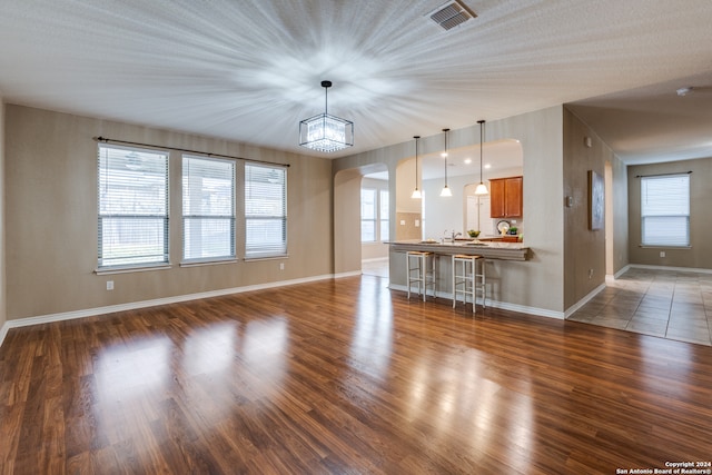 unfurnished living room with dark hardwood / wood-style flooring and a textured ceiling