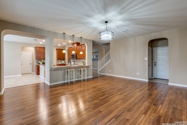 unfurnished living room featuring light hardwood / wood-style floors and a chandelier