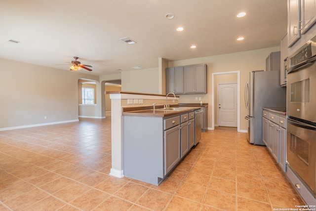 kitchen featuring stainless steel appliances, sink, gray cabinetry, ceiling fan, and light tile patterned flooring