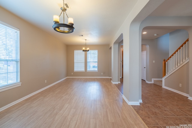 empty room featuring light hardwood / wood-style floors and a chandelier