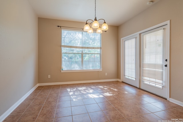 interior space with tile patterned flooring, a healthy amount of sunlight, and an inviting chandelier