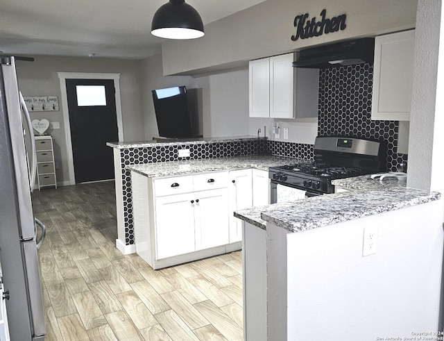 kitchen with appliances with stainless steel finishes, white cabinetry, light hardwood / wood-style flooring, and kitchen peninsula