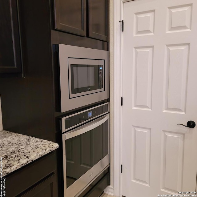 kitchen with light stone counters, appliances with stainless steel finishes, and dark brown cabinetry