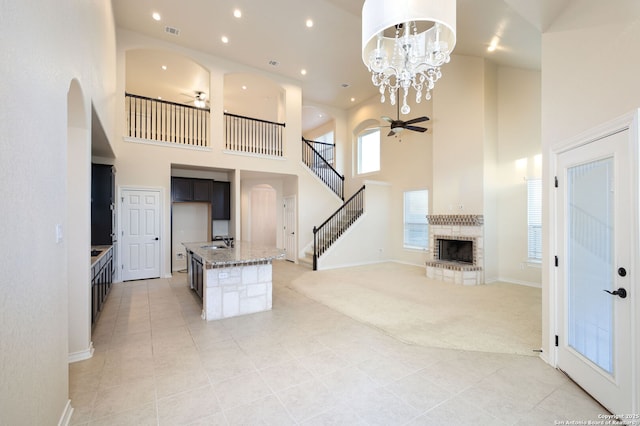 7270 Lunar Eclipse, Converse, TX 78109 - unfurnished living room featuring a ceiling fan, a high ceiling, light tile patterned floors, light colored carpet, and a sink