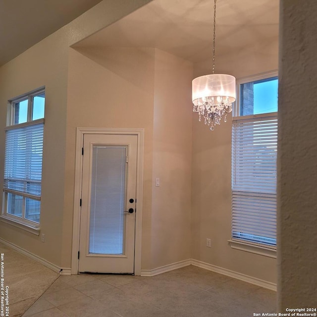 interior space featuring light tile patterned floors and a chandelier