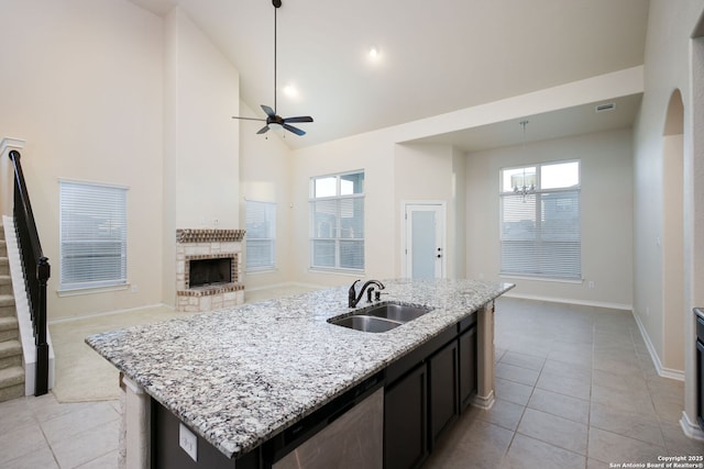 7270 Lunar Eclipse, Converse, TX 78109 - kitchen with a sink, open floor plan, light tile patterned flooring, a brick fireplace, and a ceiling fan