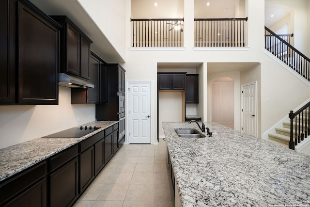 7270 Lunar Eclipse, Converse, TX 78109 - kitchen with a sink, under cabinet range hood, a high ceiling, light stone counters, and black electric stovetop