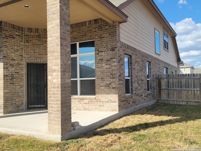 view of side of property with a lawn and a patio