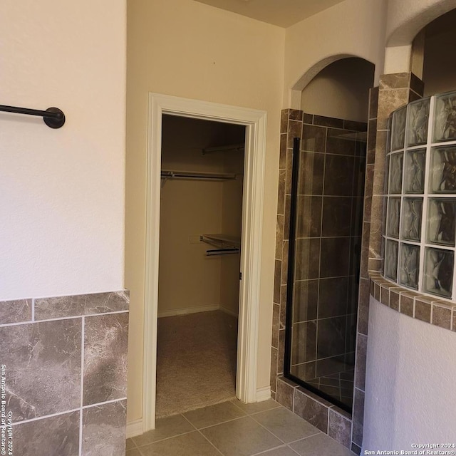 bathroom with tile patterned flooring and walk in shower