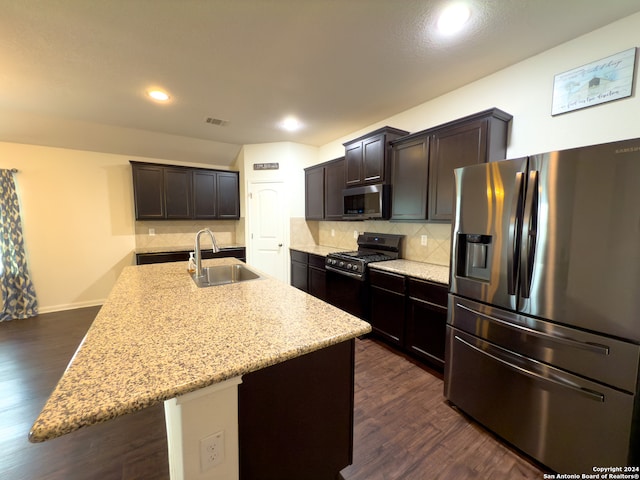 kitchen featuring a center island with sink, appliances with stainless steel finishes, sink, and dark hardwood / wood-style floors