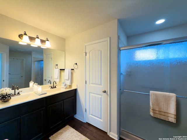 bathroom featuring walk in shower, hardwood / wood-style floors, and vanity