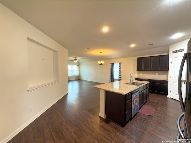 kitchen featuring ceiling fan with notable chandelier, sink, a kitchen island with sink, and dark hardwood / wood-style flooring