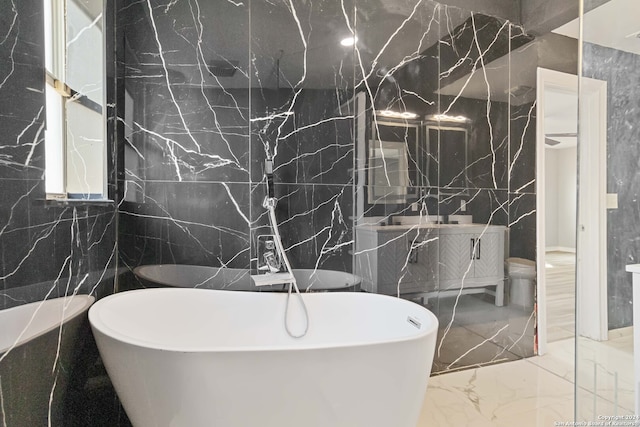 bathroom featuring tile walls, a bathtub, and vanity