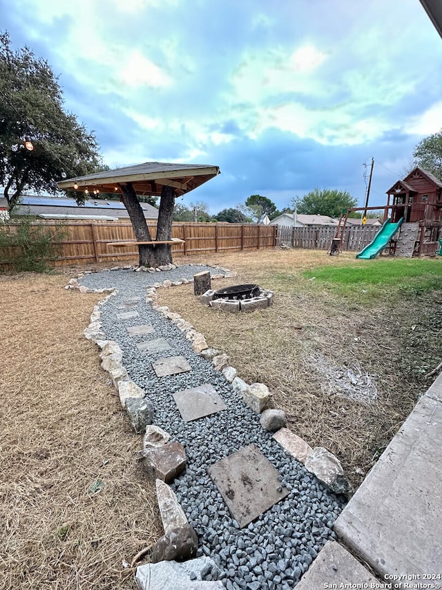 view of yard with a playground and a fire pit