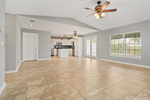 unfurnished living room with vaulted ceiling, ceiling fan, and light tile patterned flooring