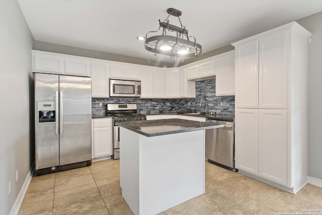 kitchen with a center island, sink, white cabinetry, hanging light fixtures, and stainless steel appliances