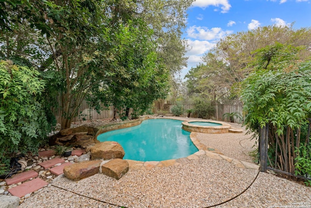 view of swimming pool with an in ground hot tub