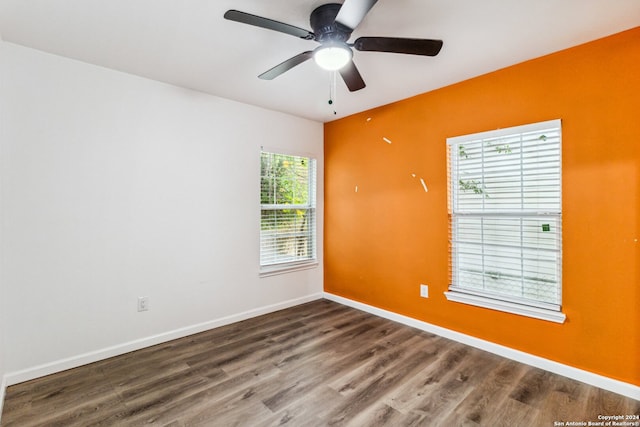 spare room with dark wood-type flooring, ceiling fan, and plenty of natural light