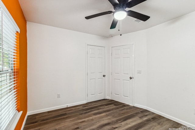 unfurnished bedroom featuring dark wood-type flooring, ceiling fan, and a closet