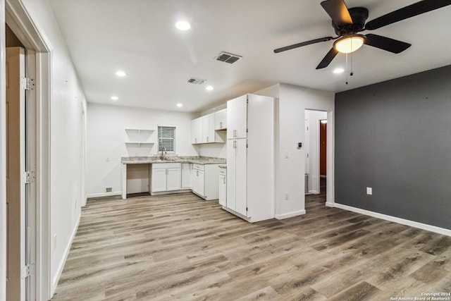 kitchen with white cabinets, light hardwood / wood-style floors, ceiling fan, and sink