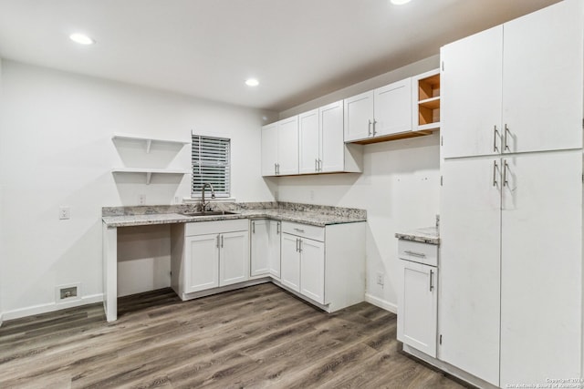 kitchen featuring white cabinets, dark hardwood / wood-style flooring, sink, and light stone counters