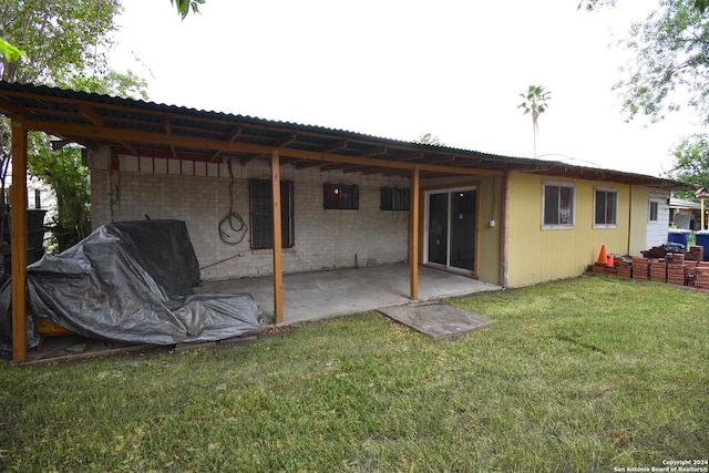 back of property featuring a patio area and a lawn