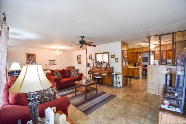 living room with a wall mounted air conditioner and ceiling fan with notable chandelier