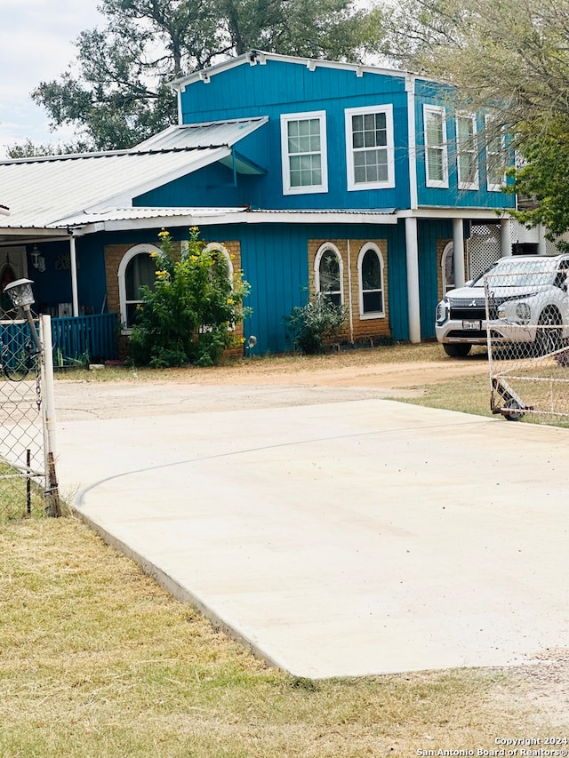 view of home's exterior featuring metal roof, concrete driveway, and a carport