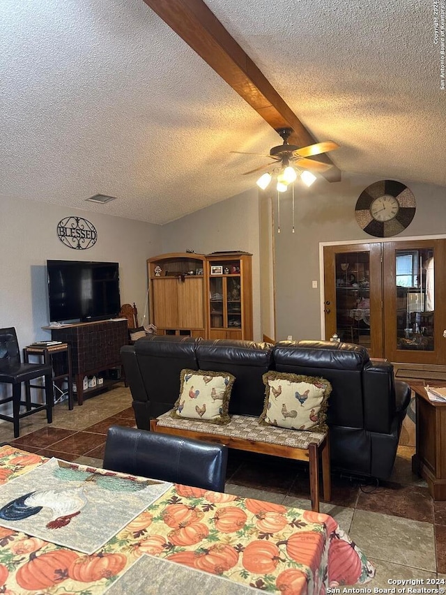 living room with beamed ceiling, a textured ceiling, and ceiling fan