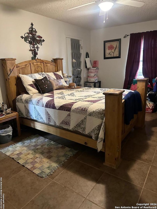 tiled bedroom with a textured ceiling and ceiling fan