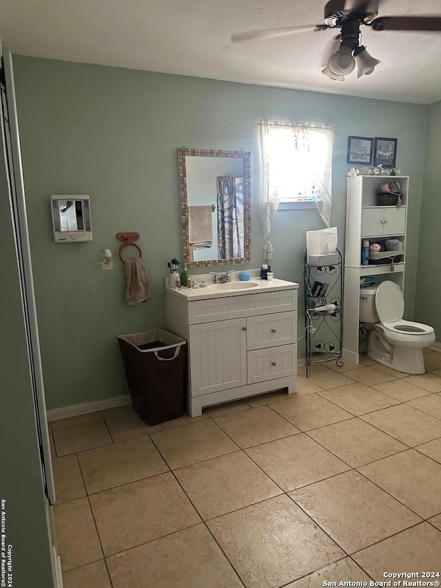 bathroom featuring toilet, vanity, tile patterned floors, and ceiling fan