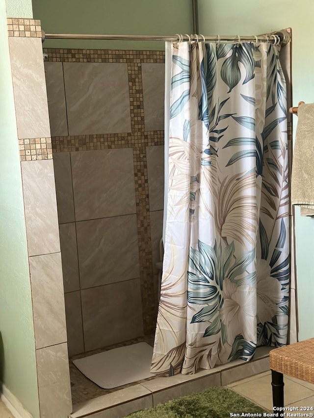 bathroom with a shower with shower curtain and tile patterned floors