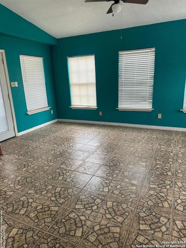 unfurnished room with a textured ceiling, ceiling fan, and vaulted ceiling