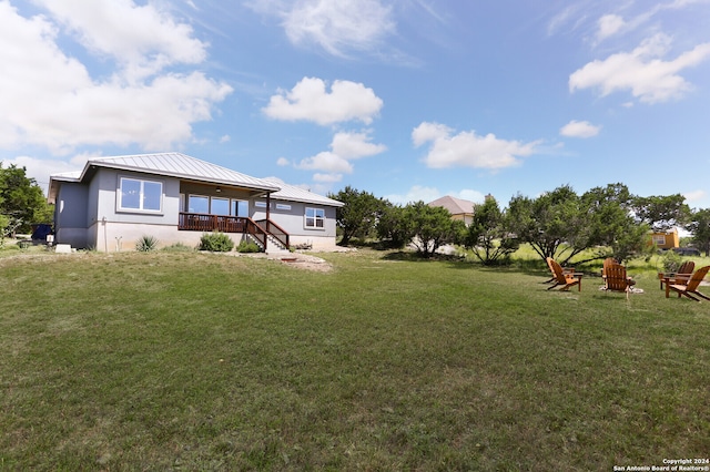 rear view of property featuring a lawn