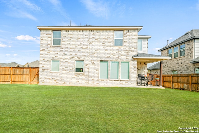 rear view of house with a lawn and a patio area