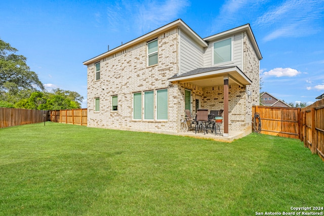 back of property featuring a patio and a yard