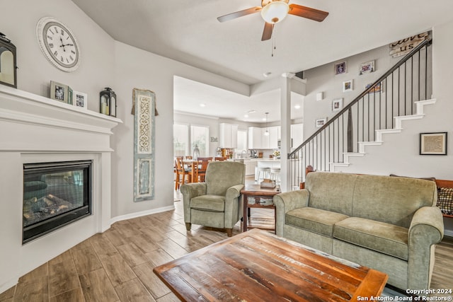 living room with ceiling fan and light hardwood / wood-style flooring