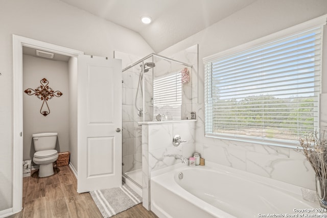 bathroom featuring hardwood / wood-style floors, shower with separate bathtub, vaulted ceiling, and toilet