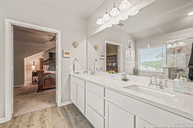 bathroom with walk in shower, vanity, hardwood / wood-style floors, and vaulted ceiling