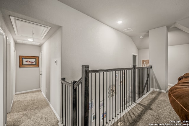 hall featuring light colored carpet and vaulted ceiling