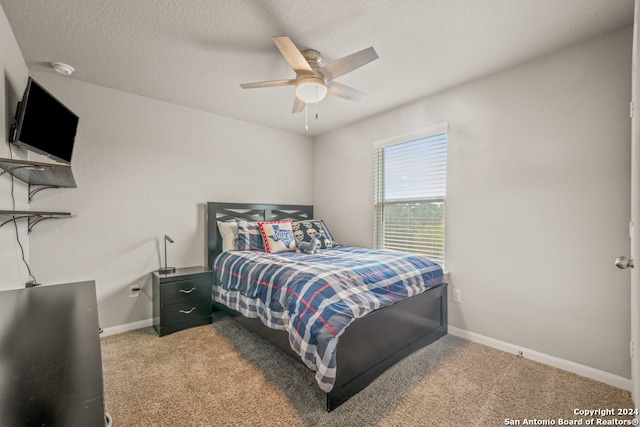 carpeted bedroom featuring a textured ceiling and ceiling fan