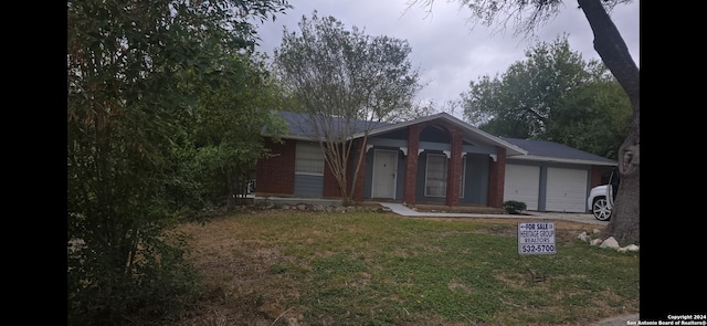 ranch-style home with a front lawn and a garage