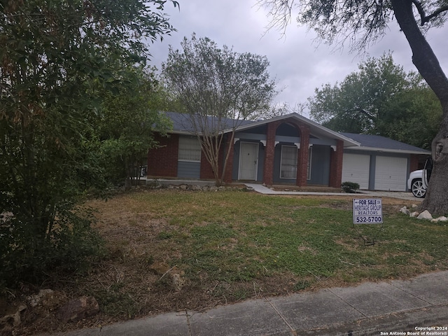 ranch-style home with a garage and a front yard