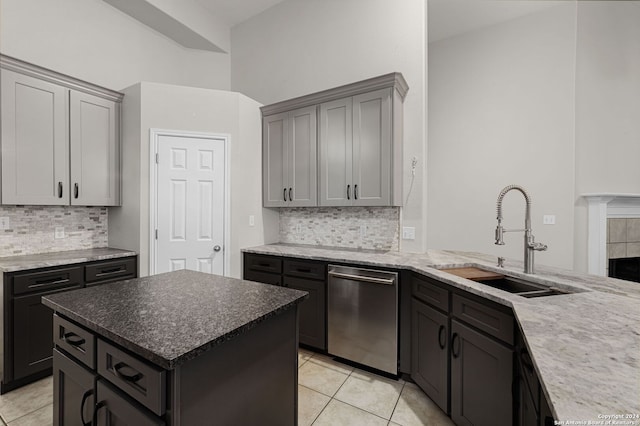 kitchen featuring dishwasher, a center island, sink, gray cabinets, and light tile patterned floors